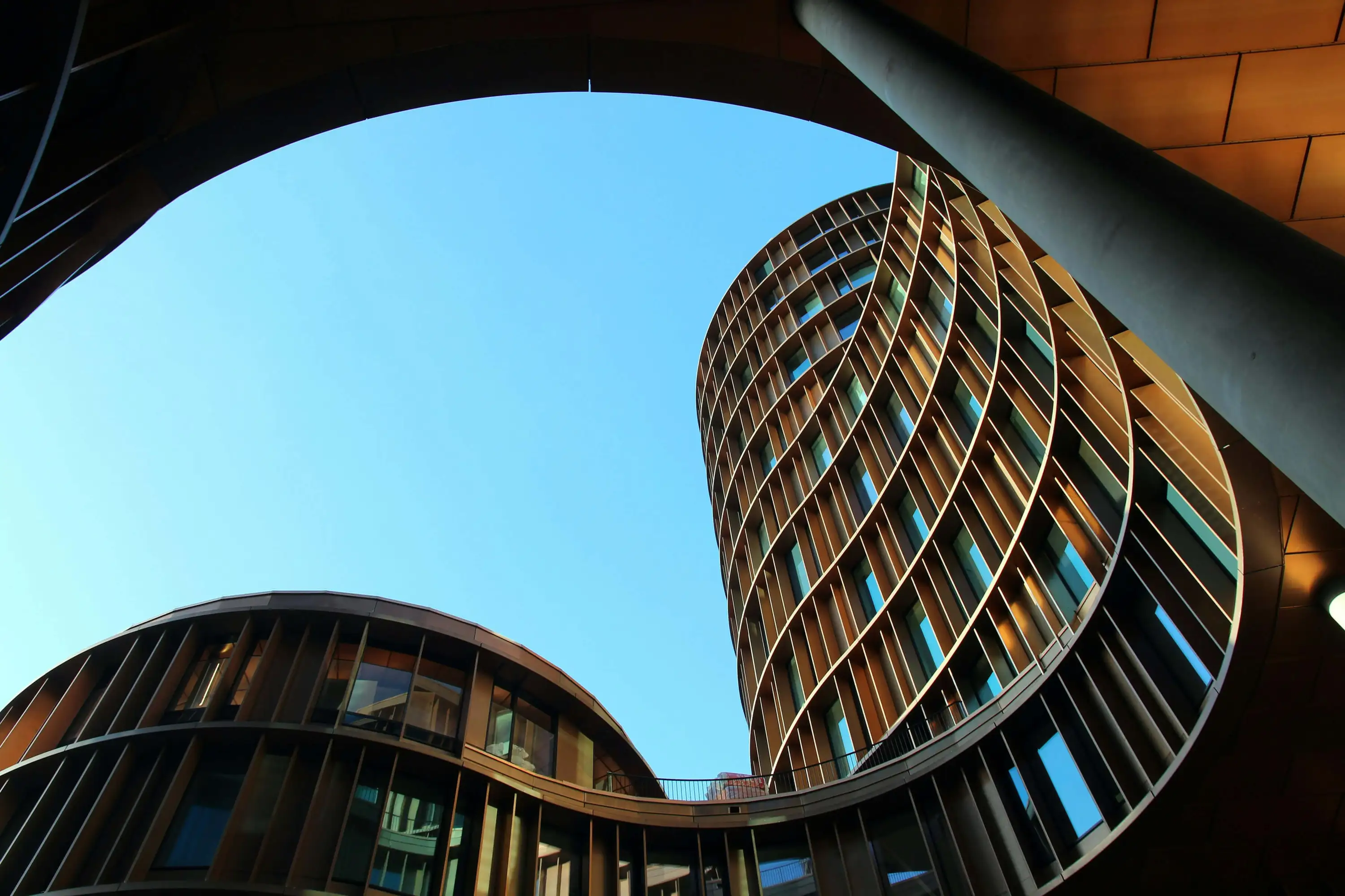 Geschwungene Holzfassaden moderner Gebäude symbolisieren nachhaltige Personalbesetzungen mit Heinrich & Coll.